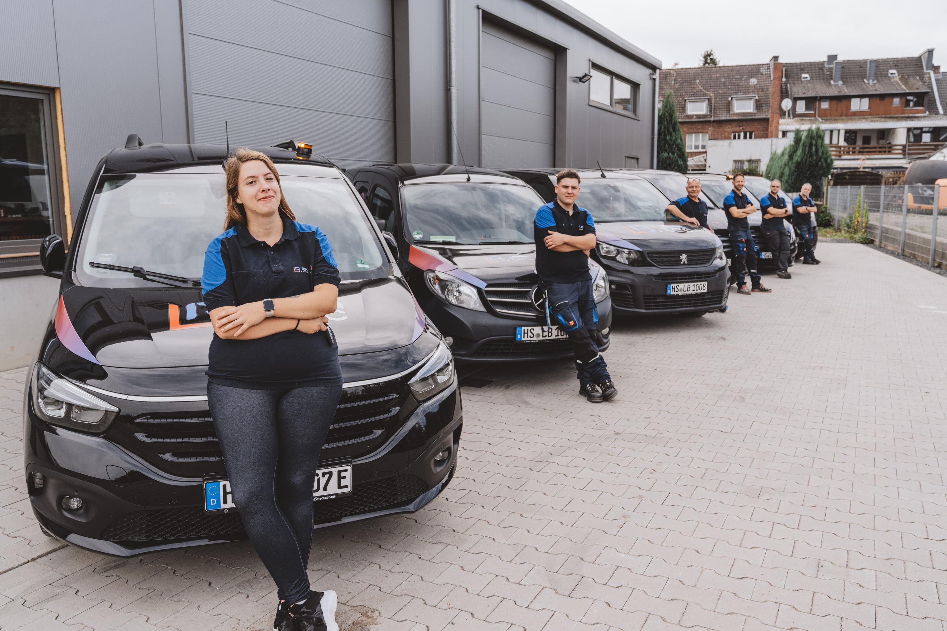Das Team der LB.tec GmbH mit den Einsatzfahrzeugen vor der Zentrale in Übach-Palenberg